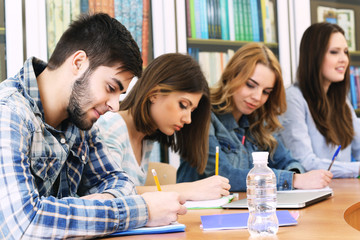 Group of students sitting at table in library