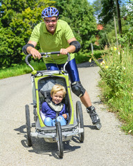 Vater skatet mit dem Sohn im Buggy