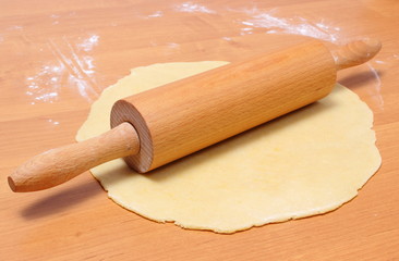Yeast cake and rolling pin on wooden table