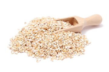 Barley groats with wooden spoon isolated on white background