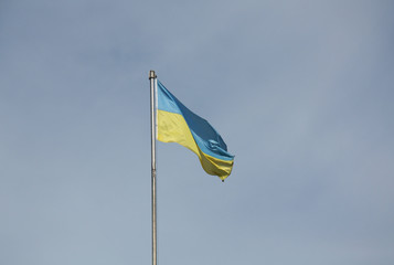 Waving flag of Ukraine on the blue sky