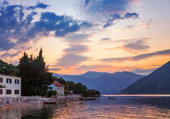 Fototapeta premium Sunset on the sea with theа foggy mountains