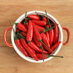 Red thai chili peppers in red bowl on wood background - 78964518