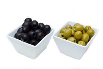 Bowls with green and black olives on white background
