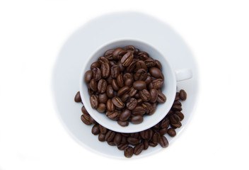Cup with coffee beans on white background top view
