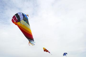 Colorful kites flying in a cloudy sky