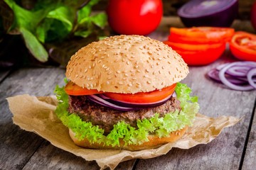 homemade burger with fresh green lettuce, tomato and red onion