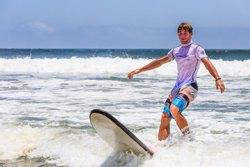 Jugendlicher surft im Atlantik