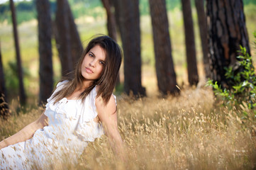 Fototapeta na wymiar Beautiful young woman sitting in grass in the countryside