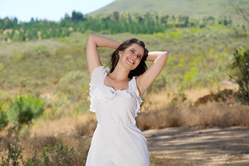 Naklejka na ściany i meble Happy smiling young woman enjoying nature