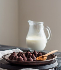 candy chocolate truffles on a plate of dark and cream in a jug,