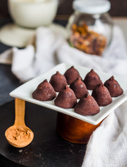 chocolate truffles, cocoa powder in a wooden spoon