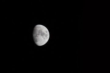 Waxing gibbous moon over dark sky at night