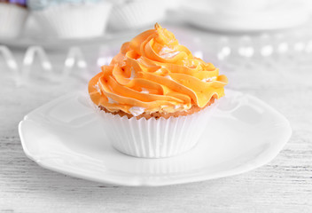 Delicious cupcakes on plate on table close-up