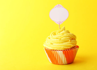 Delicious cupcake with inscription on color background