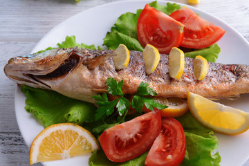 Tasty baked fish on table close-up