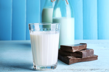 Glass and bottles of milk with chocolate chunks