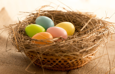 Macro shot of colorful Easter eggs lying in nest on the table