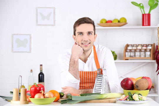 Man at table with different products and utensil in kitchen