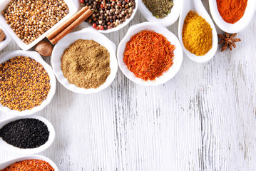 Different kinds of spices in ceramics bowls and spoons