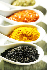 Different kinds of spices in ceramics spoons, close-up,