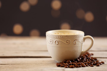 Cup of coffee on table on brown background