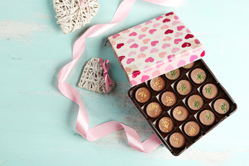 Gift box with tasty chocolate candies on wooden table