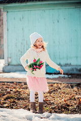 Fototapeta premium happy child girl on the walk in early spring with flowers