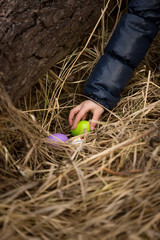 Closeup shot of girls hand taking Easter egg from the nest