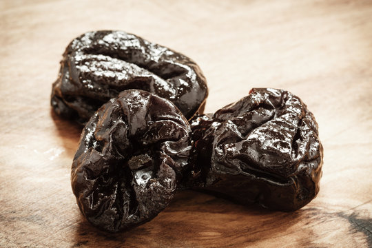 dried plums prunes on wooden table