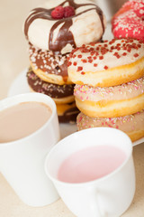donuts on  plate with cups