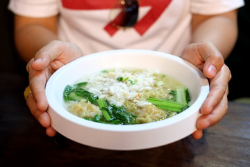 Chinese noodle and wonton soup with crab meat in a bowl