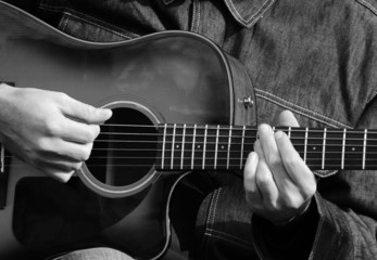 Close up of male hands playing guitar in black and white © irishmaster
