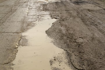 Muddy puddle on tarmac road