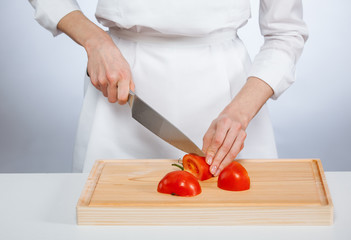 Cook cutting fresh tomato
