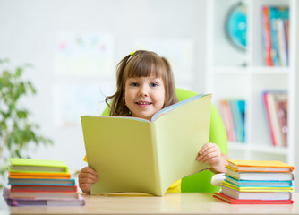 Fototapeta premium kid girl with opened book at home