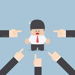 Businessman being pointed by a lot of hands
