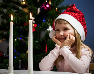 Pretty little girl looking on fire of candles