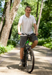 Naklejka premium Happy young man riding on bicycle