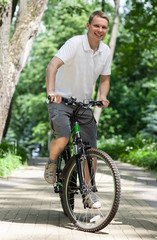 Naklejka premium Happy young man riding on bicycle