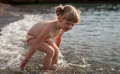 Adorable little girl playing on the seashore