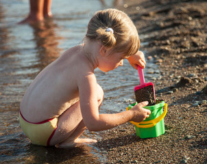 Little girl playing on the seashore