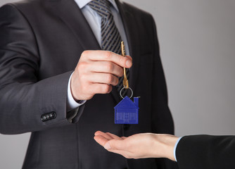 Businessman giving a key to woman's hand