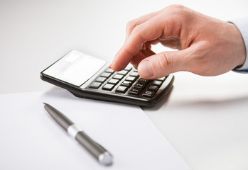 Hand of businessman using calculator