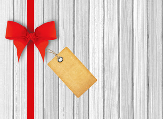 white wooden background with beautiful red bow and tag
