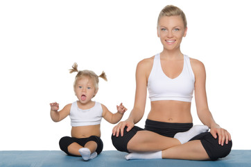 Happy mom and daughter engage in fitness on mat