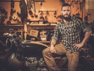 Fototapeta na wymiar Mechanic building vintage style cafe-racer motorcycle 