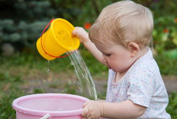 Charming baby girl playing with water