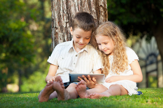 Children with tablet pc outdoors