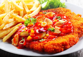 Close up Saucy Crumbled Thin Zigeunerschnitzel with Fries
